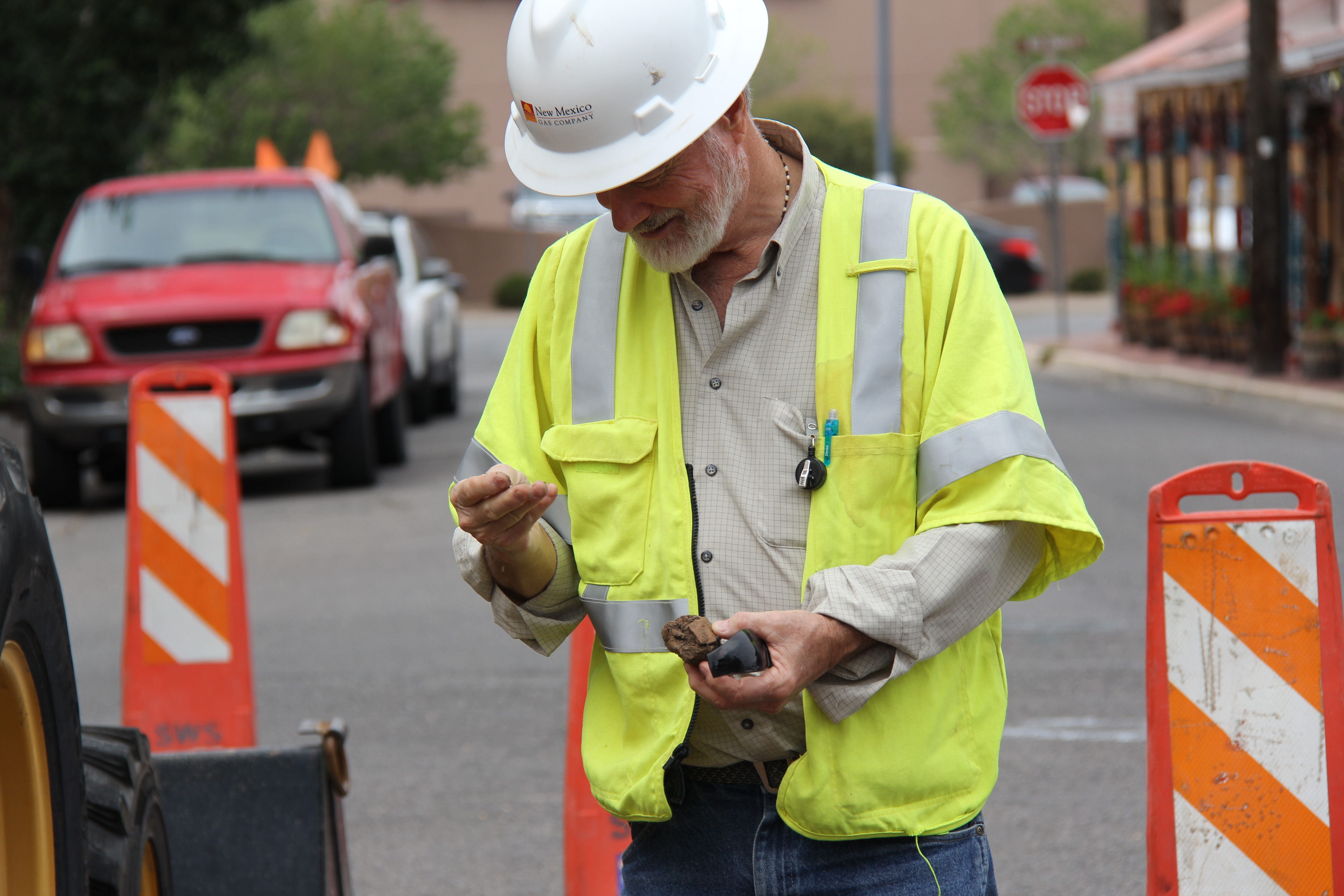 NMGC's environmentalist examines pottery found at a worksite. 